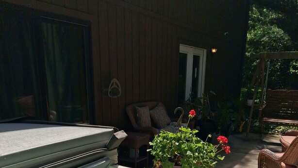 Ett bubbelbad med vatten, ett trädäck och en stol.