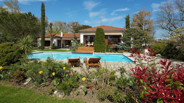 A house with a swimming pool, surrounded by lush greenery and a well-maintained garden. - Architect-designed villa in a garden paradise with 13x6 pool and tennis court (saint-jean)