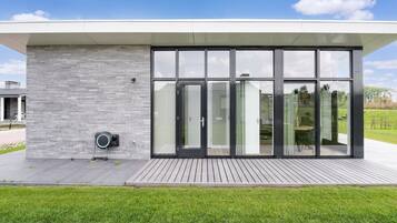 Een modern gebouw met grote glazen deuren en een gevel van grijs natuursteen.