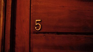 A wooden door with a number '5' on it.