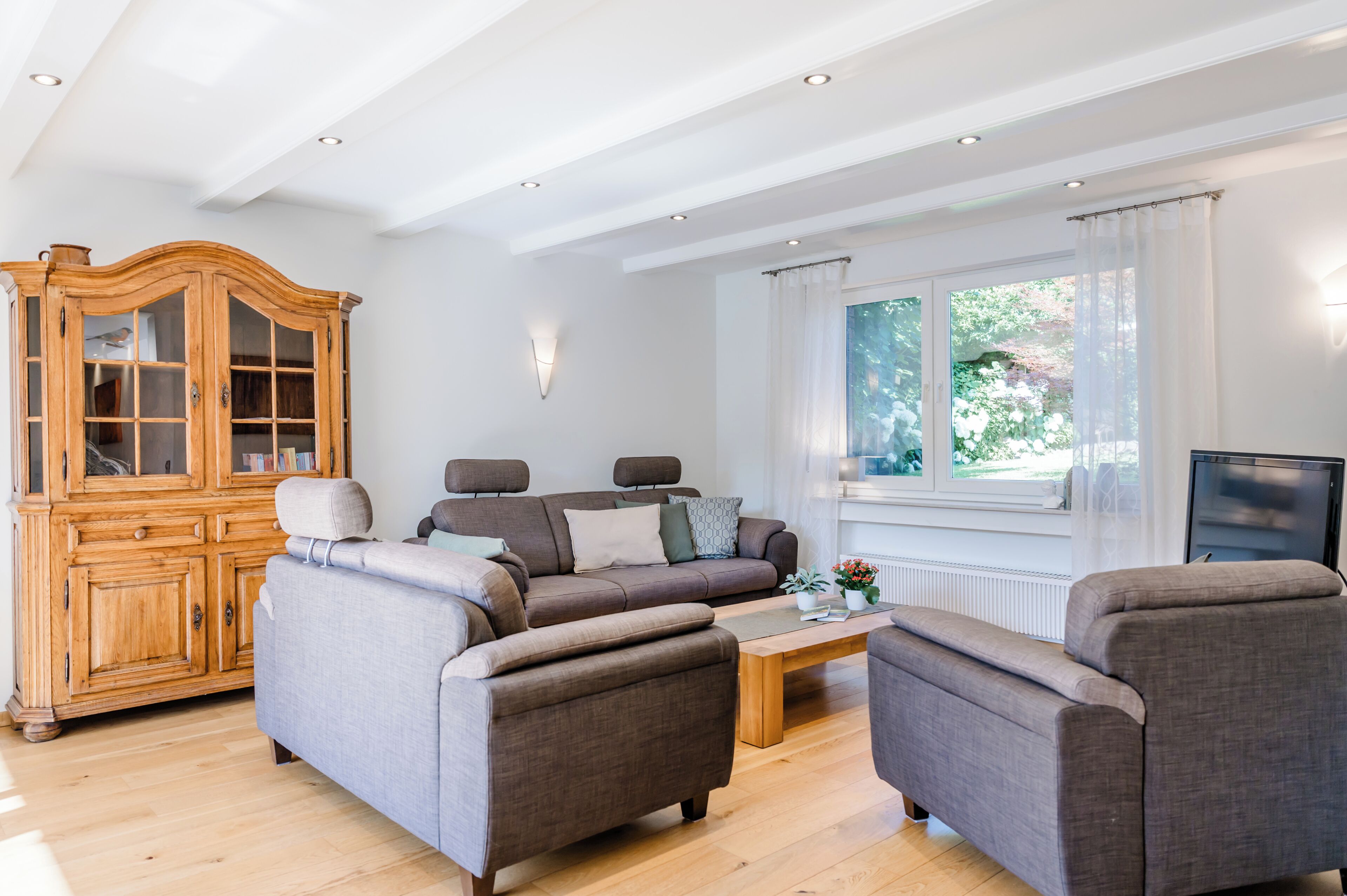 Wohnzimmer mit Blick in den Garten und große Sitzgarnitur