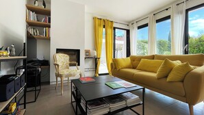 Ein modernes Wohnzimmer mit einer Couch, einem Sessel, einem Couchtisch und einem Bücherregal.