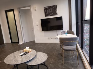 Apartamento premium, 1 quarto, vista para a cidade | Área de estar | Smart TV 42 polegadas com canais digitais