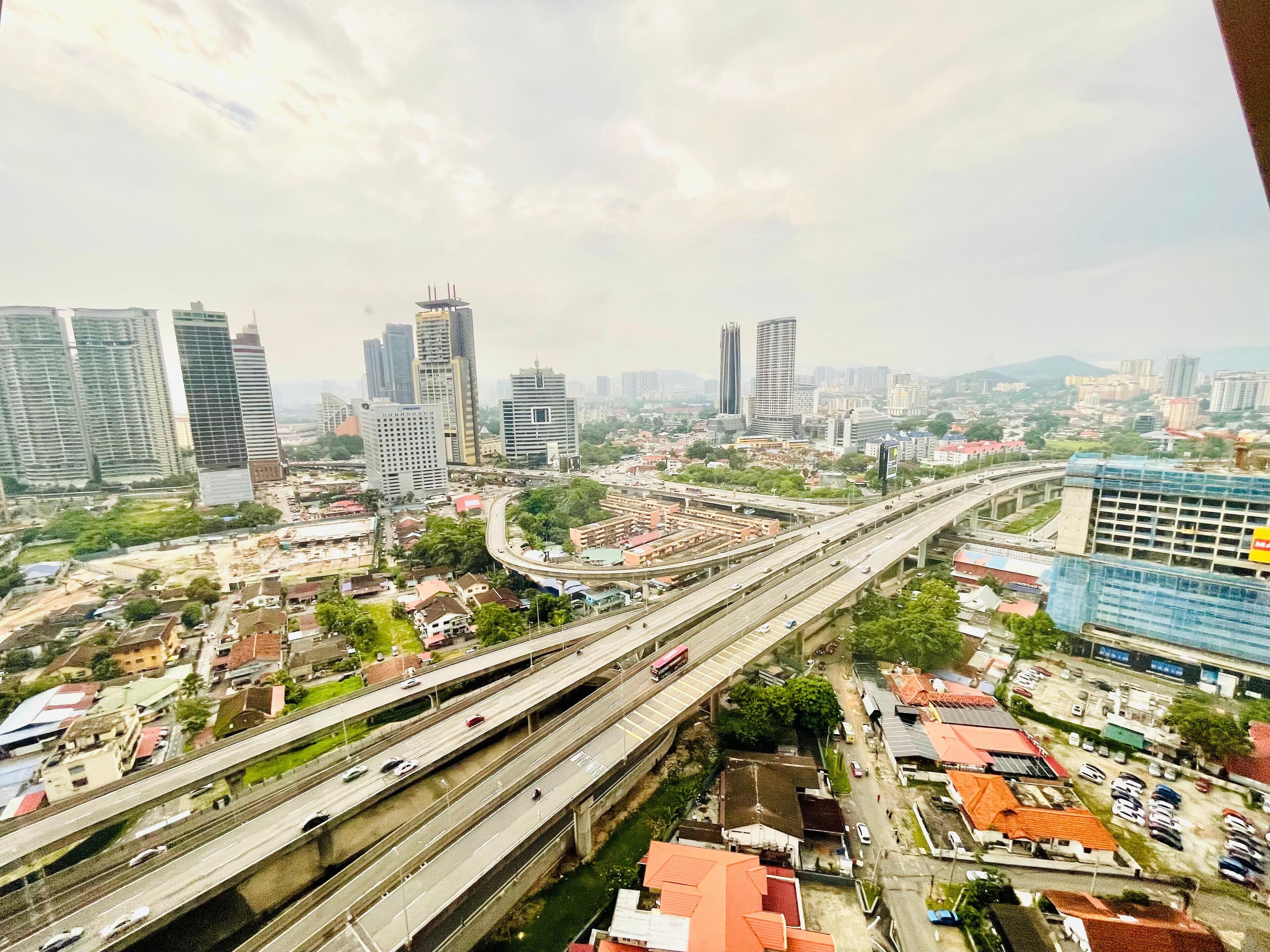 Un paysage urbain caractérisé par de nombreux immeubles de grande hauteur, un réseau autoroutier complexe et un mélange de zones résidentielles et commerciales.