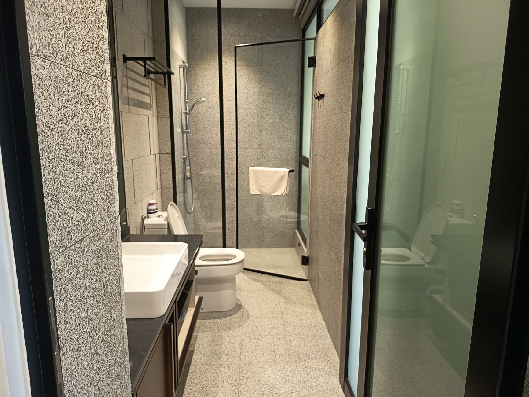 Une salle de bain moderne avec une douche à parois de verre, des toilettes et un lavabo.