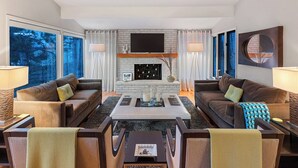 A modern living room with two sofas, a coffee table, and a fireplace.