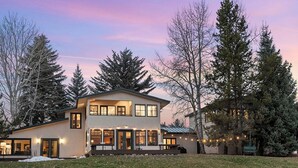 A two-story house with a large front porch and a covered outdoor seating area.
