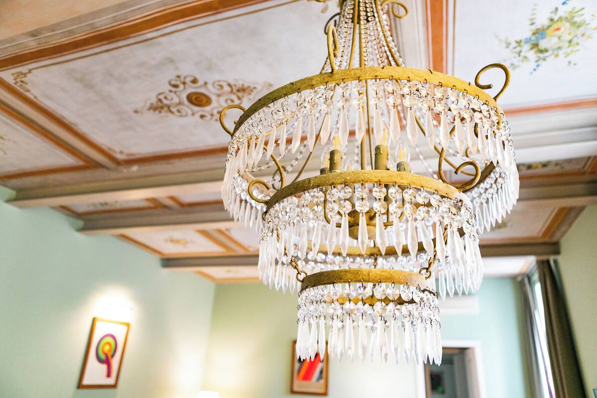 Un lustre composé de plusieurs niveaux de cristaux suspendus à une armature dorée.