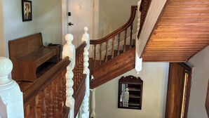 Un escalier en bois avec des balustrades blanches et une porte blanche en haut.