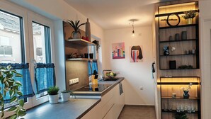 A modern kitchen with a central island, built-in shelves, and a variety of plants. - Top modern vacation home family friendly! (Brunnthal)