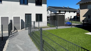 A modern residential building with a paved walkway and a fenced yard. - Top modern vacation home family friendly! (Brunnthal)