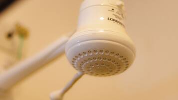 A white showerhead with a circular pattern of holes and a control knob.
