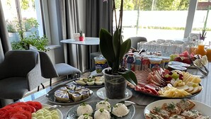 Une table de buffet proposant divers plats, notamment des salades, des fromages et des amuse-gueules.