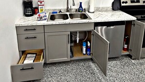 A compact kitchen with a sink, cabinets, and a countertop.