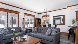 A living room with a grey sofa, a coffee table, and a bookshelf. - Snowbridge (Blue Mountains)