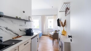 A modern kitchen with a marble countertop, a dishwasher, and a dining area with a table and chairs. - Apartment in Koblenz Near Deutsches Eck (Koblenz)