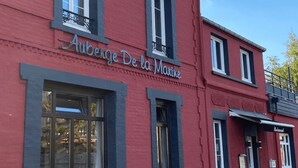 Ein rotes Gebäude mit dem Schild "Auberge De la Marine", das ein Restaurant kennzeichnet.
