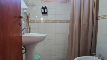 Chuveiro, bidê, toalhas de banho, sabonete