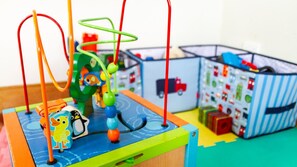 A children's play area with a colorful toy structure, a small toy penguin, and a toy car. - Cliff Cottage - Noraville (Noraville)