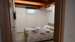 A bedroom with a bed, a window, and a door.