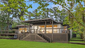 A modern house with a covered deck, a staircase, and a lawn. - Family Cove Retreat - newly remodeled! (Point Blank)