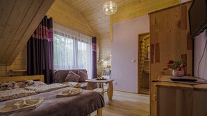 Ein gemütliches Schlafzimmer mit Holzeinrichtung, einem Bett, einem kleinen Tisch und einem Schreibtisch.