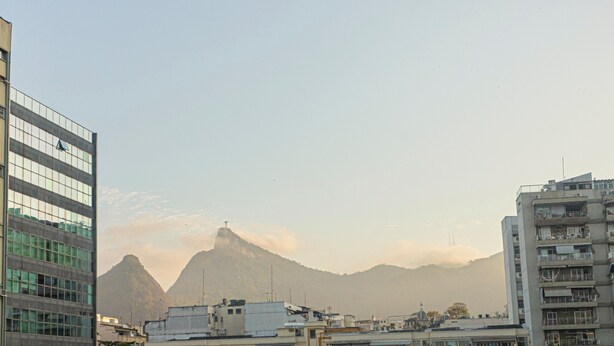 A cityscape with modern buildings and a prominent mountain in the background. - SUH Catete 02 Christ View (Rio de Janeiro)