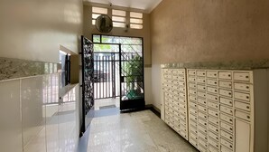 A hallway with a tiled floor, a black gate, and a row of white lockers. - SUH Catete 02 Christ View (Rio de Janeiro)