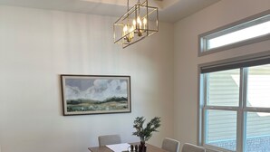 A dining area with a wooden table, benches, and a hanging light fixture. - Peaceful Retreat w/ Trail Access and Convenience (Bella Vista)