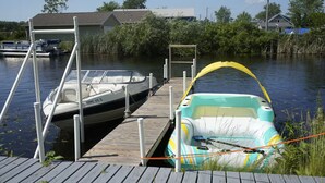 Un muelle con un barco blanco y un bote inflable de colores.