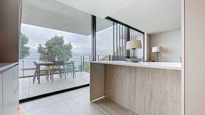 A modern kitchen with a large window, a dining area with a table and chairs, and a view of the outdoors. - Monumental Sea Sky by Atlantic Holiday (Funchal)