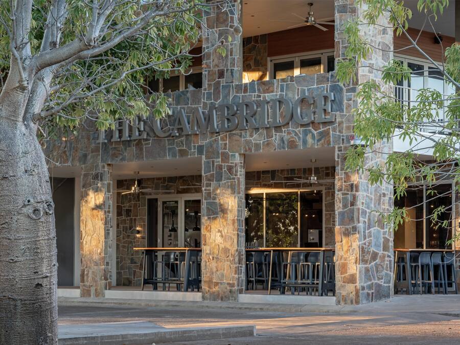 The Cambridge Hotel with stone facade and outdoor seating area.