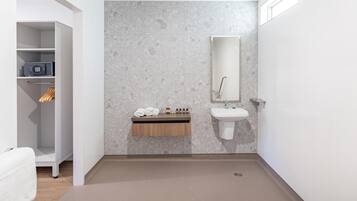 Une salle de bain moderne avec un mur en marbre, un meuble-lavabo en bois, un évier et un porte-serviettes.