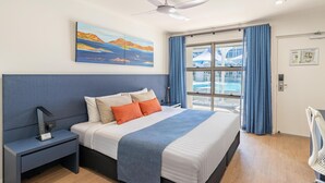 A modern hotel room with a large bed, a nightstand, a desk with a chair, a window with curtains, and a painting on the wall. - Best Western Cambridge Hotel Kununurra (Kununurra)