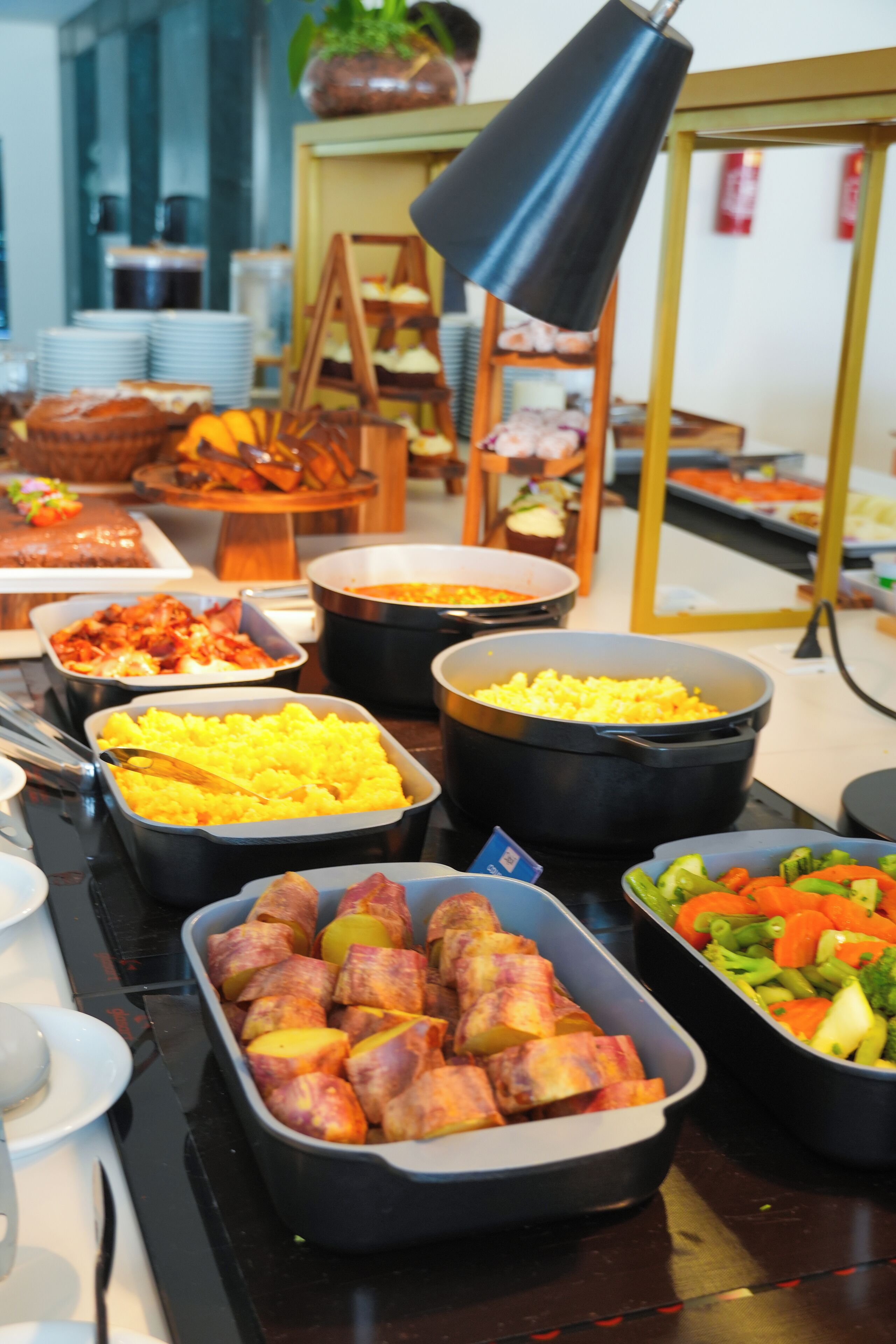 A buffet with various dishes including potatoes, vegetables, and other prepared foods.