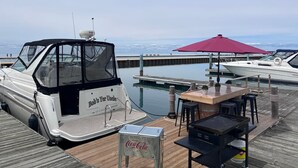 A docked boat with a table and chairs, a red umbrella, and a Coca-Cola cooler. - Bob's Yer Uncle in Port Dalhousie (St. Catharines)