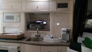 A compact kitchenette with a microwave, toaster oven, coffee maker, and a sink. - Bob's Yer Uncle in Port Dalhousie (St. Catharines)