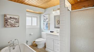 A bathroom with a bathtub, toilet, and vanity.