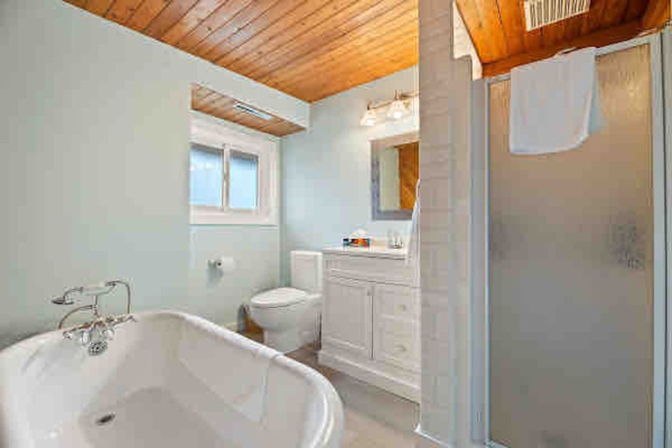 A bathroom with a bathtub, toilet, and vanity.