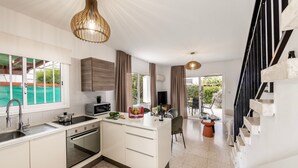 A modern kitchen with a central island, a built-in oven, and a large window. - Larnaca Seaside Villa Marina 43 (Pervolia)