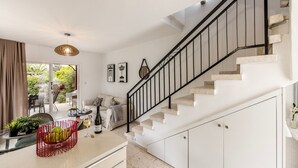 A modern kitchen with a staircase, a dining area, and a view of the outdoors. - Larnaca Seaside Villa Marina 43 (Pervolia)