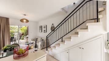 A modern kitchen with a staircase, a dining area, and a view of the outdoors.