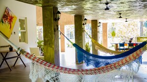 A hammock in a spacious room with a view of the outdoors, wooden flooring, and a painting on the wall. - Casa c Wifi Churrasq Pisc red rio Pet Friendly (Benevides)
