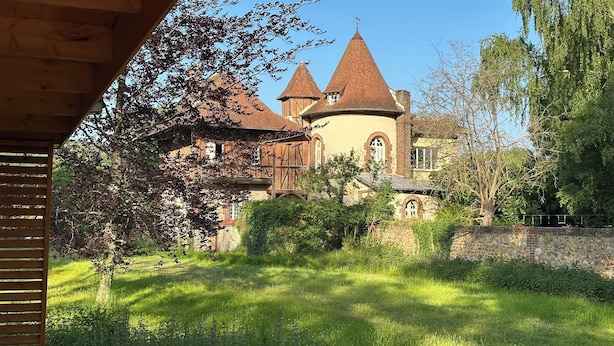 A historic building with a central tower and two smaller towers, surrounded by lush greenery. - Unique. "Villa fleurie" on the Fontainecourt estate with artists' studios. (Glos-sur-Risle)