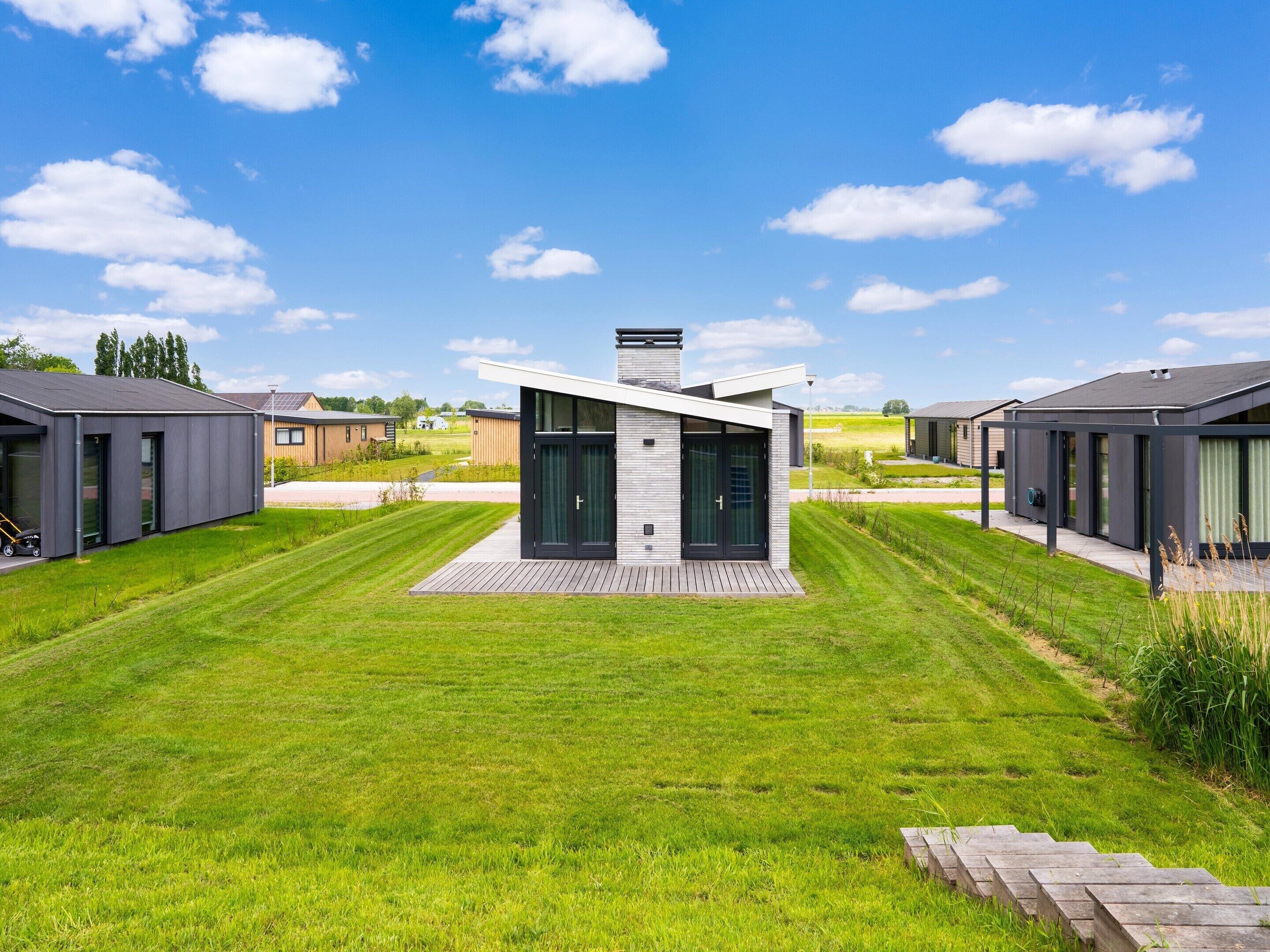 Een modern gebouw met een plat dak, grote ramen en een centrale schoorsteen.