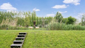 Een grasveld met een houten trap die een heuvel op leidt.