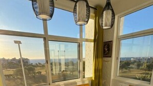 Zona de menjador amb una taula gran, cadires grogues i llums penjants.