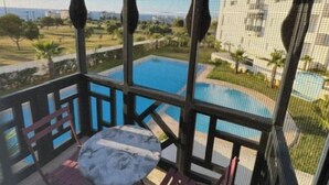 Un balcó amb vistes a una piscina i un edifici.