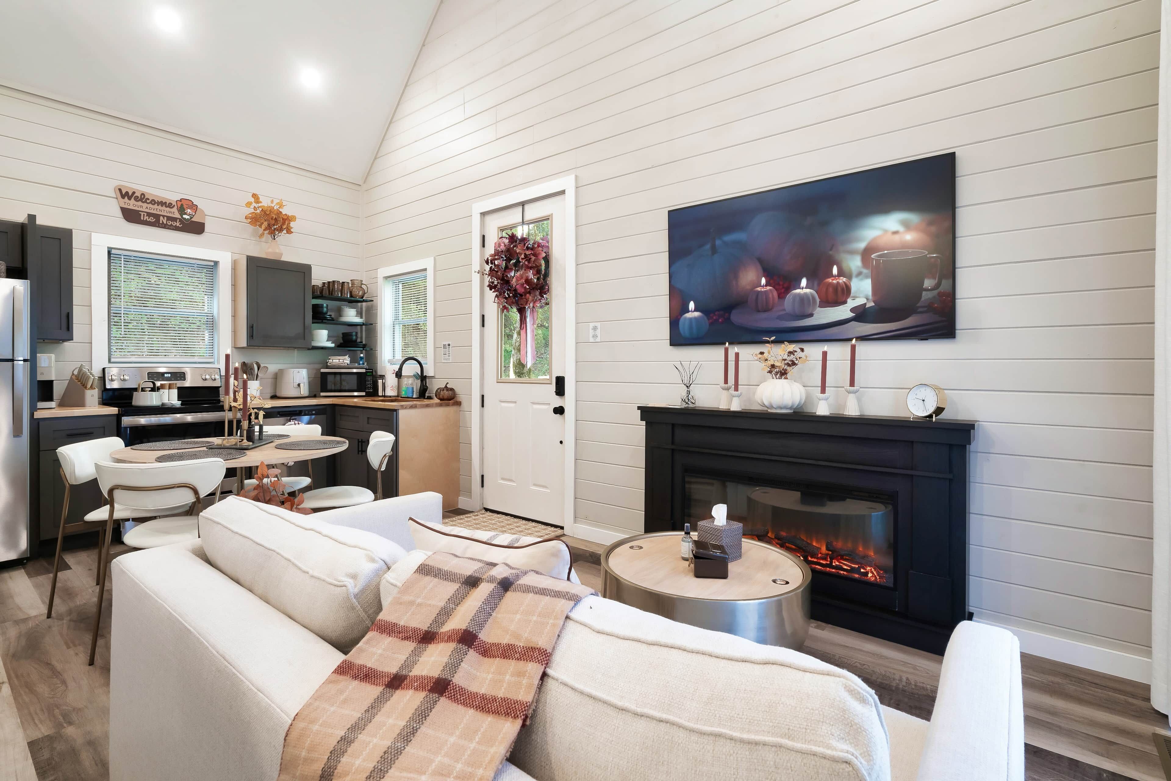 Una sala moderna con chimenea, comedor y cocina.