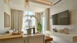A modern kitchen with a wooden countertop, a built-in oven, and a large window with curtains. - Caribbean Coastal View Apartment (Playa Juan Dolio)